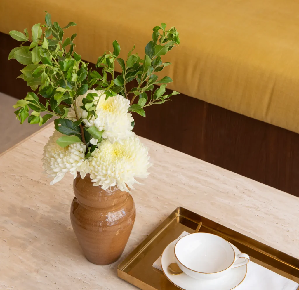 Jarrón con flores y taza en la zona de espera de El Salón, estética saludable en Palma